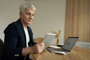 Yaşlı bir adam akşamları iş yerinde çalışır. Bilgisayardaki müşteriye finansal mesaj. Ekonomist bir şirket raporu hazırlar. Programcı çevrimiçi projeler yaratır.