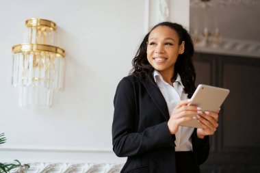 Bayan bir gazeteci müşterilere postayla bir mesaj basar. Öğrenci bir tablette internette sörf yapıyor. Yönetici ofiste çalışıyor. Finansör bakiyeyi internetten kontrol eder.