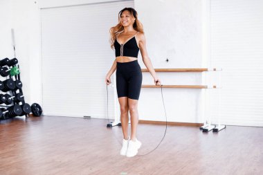 Kardiyo sistemi üzerinde aktif egzersizler. Sportif bir bayan antrenör bunu parlak bir spor salonunda eğitiyor. Sağlıklı bir yaşam tarzı ve dayanıklılık..