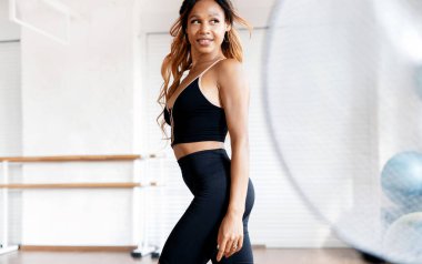 Egzersiz sonrası dinlenme, kardiyo sisteminde aktiftir. Sportif bir bayan antrenör bunu parlak bir spor salonunda eğitiyor. Sağlıklı bir yaşam tarzı ve dayanıklılık..