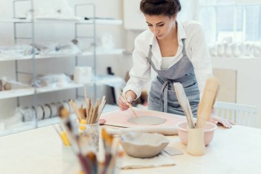 Üretim süreci. Heykeltıraş el yapımı sofra takımı yapar. Seramik ustası stüdyo işyerinde profesyonel bir iş yapıyor. Bir kadının hobisi kille çalışmaktır..