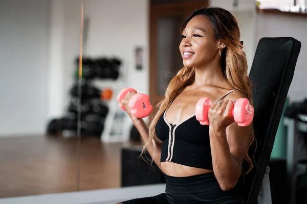 一个健美的女人在一个明亮的健身工作室里训练一个 哑铃练习在有氧运动系统中很活跃 健康的生活方式和毅力 — 图库照片