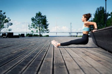 Kilo vermek için kardiyo eğitimi. Kadınlar için rahat kıyafetler. Şehirde spor yapıyor. Profesyonel bir antrenör antrenmandan önce ısınma egzersizleri yapar. Sporcunun sağlıklı bir yaşam tarzı var..