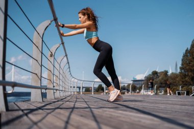 Sporcu en sevdiği işi yapıyor, sağlık için aktif olan egzersizleri. Kadın bir koç sokakta spor yapıyor..