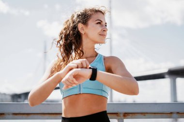Akıllı saat kalp atış hızı ölçümü. Egzersiz yapan ve koşan bir kadının portresi. Antrenör bir mesafe maratonudur. Şehirde fitness kardiyo çalışması var. Sağlık ve yaşam tarzı.