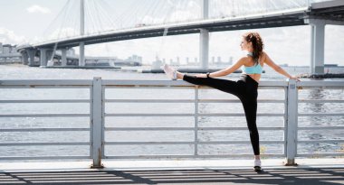 Antrenör antrenmandan önce ısınma egzersizleri yapar. Sporcunun sağlıklı bir yaşam tarzı var. Kilo vermek için kardiyo eğitimi. Kadınlar için rahat kıyafetler. Şehirde spor yapıyor mu?.