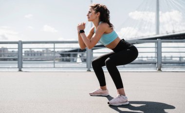 Sağlık ve yaşam tarzı, özgüven. Profesyonel koç bir mesafe maratonu için hazırlanıyor. Şehirde fitness kardiyo çalışması var. Bir kadın ısınıyor ve koşuyor..
