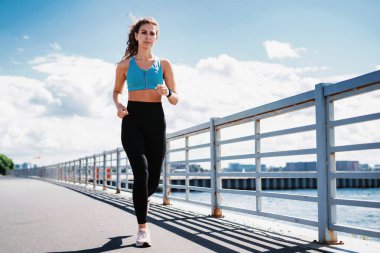 Sağlık ve yaşam tarzı, özgüven. Koç uzaktan bir maratona hazırlanıyor. Şehirde fitness kardiyo çalışması var. Bir kadın ısınıyor ve koşuyor..