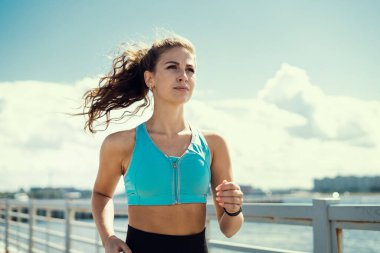 Eğitimde olan bir kadın. Sokakta egzersiz koçu, sağlıklı bir yaşam tarzı. Sokakta koşan bir sporcu.
