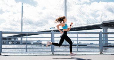 Kilo vermek için kardiyo eğitimi. Kadınlar için spor ve giysi. Şehirde spor salonu. Antrenör antrenmandan önce ısınma egzersizleri yapar. Sporcunun sağlıklı bir yaşam tarzı var..