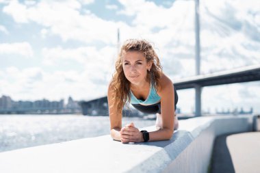 Sporcu en sevdiği çalışma egzersizlerini sağlık için yapar. Kadın bir koç sokakta spor yapıyor. Elimde akıllı bir saat var..