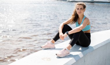 Mola ve rahat koşu kıyafetleri. Antrenör egzersiz yapar. Güçlü kadın fitness sehpası.