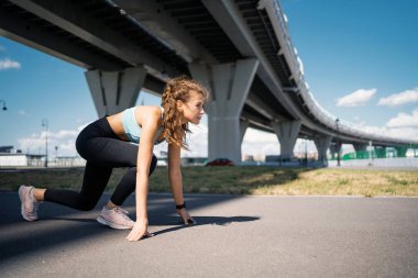 Güçlü, kendinden emin bir atlet, koşucu sağlıklı bir hayat sürüyor. Formda kalmak için kaslarını esnetme egzersizleri aktiftir. Şehirde bir kadın antrenman yapıyor..
