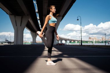 Atletik vücut, rahat koşu kıyafetleri. Antrenör egzersiz yapar. Güçlü kadın fitness sehpası.