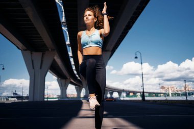 Dişi bir atlet koşuya hazırlanır ve tüm vücudu ısıtır. Araba şehirde caddede antrenman yapar. Kendine güvenen bir kadın sağlıklı bir hayat sürüyor..