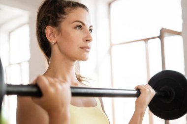 Bir kadın kulüpte aerobik yapıyor. Fitness esnemesi. Sağlıklı bir jimnastik ve zayıf bir vücut. Vücut için egzersiz yapan bir eğitmenin portresi.