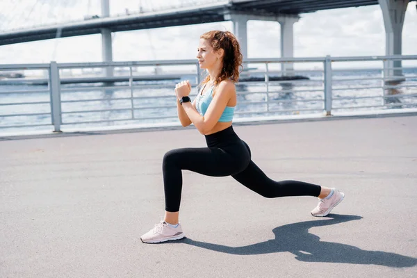 Sporcu en sevdiği çömelme egzersizlerini sağlık için yapar. Kadın bir koç sokakta spor yapıyor. Elimde akıllı bir saat var..