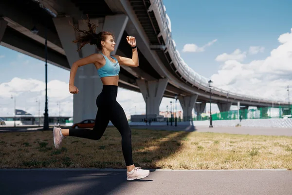 一个自信的女跑步教练在露天进行力量训练 健康的生活方式概念 身材瘦小 衣服舒适 — 图库照片