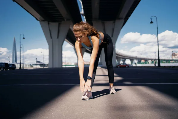 作为一名强壮 自信的运动员 跑步者过着健康的生活 一个女运动员在城里的大街上训练 燃烧体内的热量 锻炼伸展肌肉以锻炼身体是很活跃的 — 图库照片