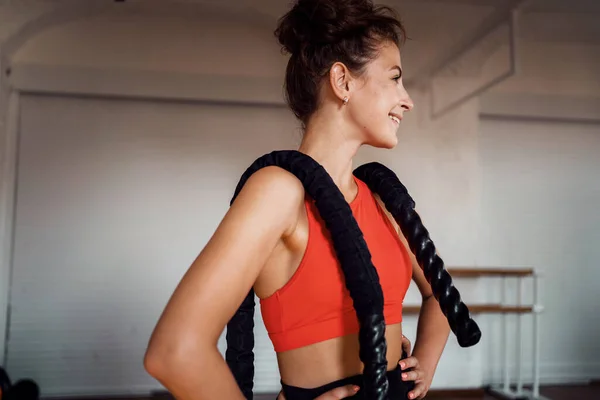 Spor malzemesi kullanıyor. İnce beden kardiyo dersleri. Kendine güvenen bir kadın ve sağlıklı bir yaşam tarzı. Bir fitness eğitmeni egzersiz yapar. Antrenman için rahat dar giysiler..