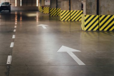 White directional arrow - road markings in a parking. Straight direction
