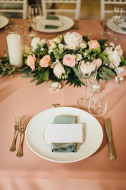 Açık şeftali renginde boş bir kartın olduğu düğün masası. Como Gölü 'ndeki villada romantik bir düğün.