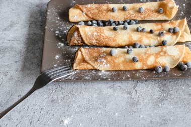 Yabanmersinli ev yapımı krep. Gri plakalar ve beton arka plan