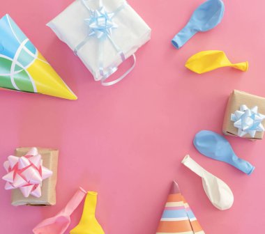 Pembe bir arka planda doğum günü süslemeleri. Balonlar ve hediyeler.