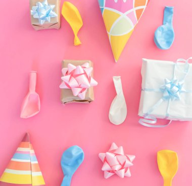 Pembe bir arka planda doğum günü süslemeleri. Balonlar ve hediyeler.