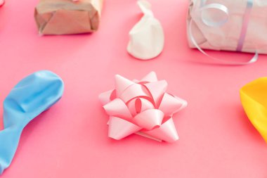 Pembe bir arka planda doğum günü süslemeleri. Balonlar ve hediyeler.