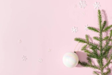 Noel arkaplanındaki şeftali ağacının dalında kar taneleriyle asılı duran Noel incili oyuncak balonu. Noel kompozisyonu. Minimum düzlük.