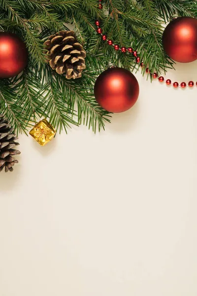Noel ağacının dalları, pastel bej arka planda Noel topları. Noel kompozisyonu. Asgari düzeyde. Düz düzen, üst görünüm.
