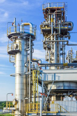 Gaz işleme tesisinde mavi gökyüzüne karşı iki soğurma sütunu duruyor..