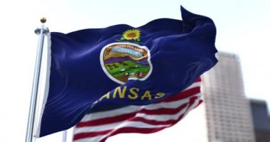 ABD 'nin Kansas eyaletinin bayrağı rüzgarda dalgalanırken arka planda Amerikan yıldızları ve çizgileri belirsizleşti. Mavi bir tarlada Kansas 'ın mührü ve fokun üstünde bir ayçiçeği. 