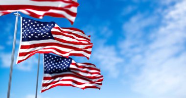 Amerika Birleşik Devletleri 'nin rüzgarda dalgalanan üç bayrağı. Arka planda hava açık. Seçici odaklanma. Demokrasi, bağımsızlık ve seçim günü. Amerikan gururunun vatansever sembolü