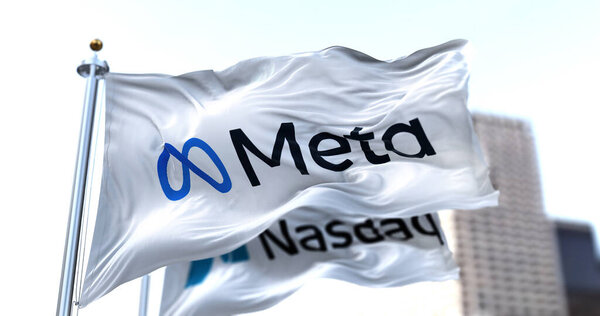 Menlo Park, CA, USA, October 28 2021: The flags of Meta and Nasdaq waving in the wind. Meta is a technology company that will replace Facebook Inc.