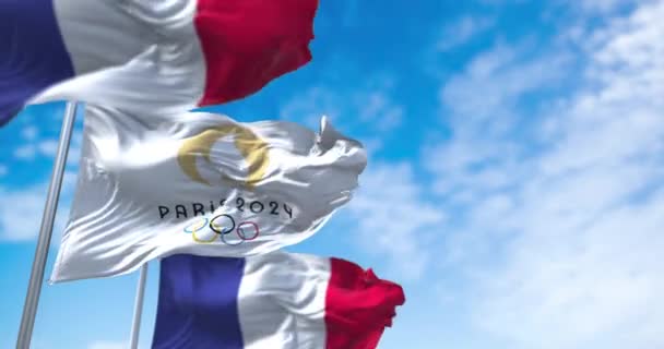 2021年7月 パリ24オリンピックの旗が2本のフランス国旗の間で風になびく パリ2024夏季オリンピックは7月26日から8月11日までパリで開催されます — ストック動画