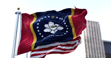 Amerika Birleşik Devletleri 'nin Mississippi eyaletinin bayrağı rüzgarda dalgalanırken arka planda Amerikan bayrağı bulanıklaşmıştı. Mississippi, 10 Aralık 1817 tarihinde 20. eyalet olarak Birliğe kabul edildi.