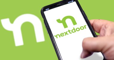 San Francisco, CA, USA, Mayıs 2021: Nextdoor uygulamasının ev ekranı el kamerasıyla çekilmiş akıllı telefon ekranı. Arka planda Nextdoor logosu bulanıklaştı. Nextdoor mahalleler için bir sosyal ağ.