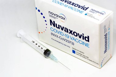 Gaithersburg, MA, USA, Aralık 2021: Novavax Nuvaxovid Covid-19 aşı kutusunun yanında beyaz bir zemin üzerinde izole edilmiş bir şırınga. Sağlık ve önleme covid-19 salgınından