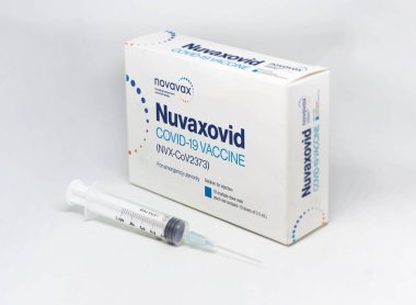 Gaithersburg, MA, USA, Aralık 2021: Novavax Nuvaxovid Covid-19 aşı kutusunun yanında beyaz bir zemin üzerinde izole edilmiş bir şırınga. Sağlık ve önleme covid-19 salgınından