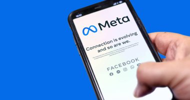 Menlo Park, CA, ABD, 28 Ekim 2021: Mavi arka planda Meta mobil uygulaması olan bir telefonu el ele tutuş. Meta, Facebook Inc. 'in yerini alacak bir teknoloji şirketi.
