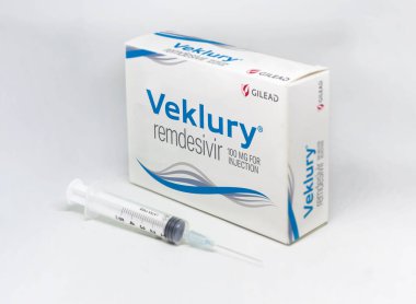 Foster City, CA, USA, December 2021: A syringe next to the Gilead Veklury Remdesivir Covid-19 treatment box isolated on a white background. Health and prevention from covid-19 pandemic clipart