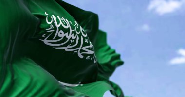 Açık bir günde rüzgarda dalgalanan Suudi Arabistan bayrağının ayrıntıları. Batı Asya ülkesi. Seçici odak.