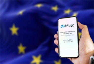 Roma, İtalya, Şubat 2022: ekranda Meta mobil uygulaması olan bir telefonu tutan ve arka planda Avrupa Birliği Bayrağı 'nın dalgalanması bulanıklaştı. Meta, Facebook 'un sahibi olduğu yeni teknoloji şirketi.