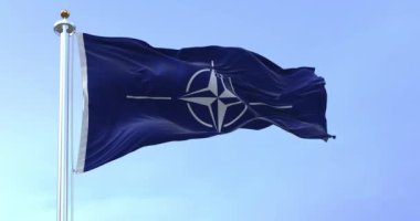 NATO (Kuzey Atlantik Antlaşma Örgütü) açık bir günde rüzgarda dalgalanan bayrak. NATO, kolektif güvenlik sistemi oluşturan uluslararası bir askeri ittifaktır.