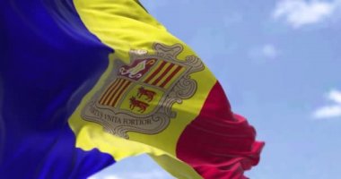 Açık bir günde rüzgarda dalgalanan Andorra bayrağının ayrıntıları. Andorra, Avrupa 'da denize kıyısı olmayan bağımsız bir mikro durumdur. Seçici odaklanma. Yavaş çekimde kusursuz döngü