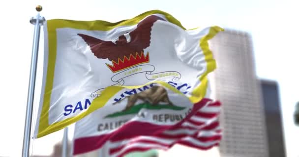 カリフォルニア州と米国の国旗を背景に 風になびくサンフランシスコ市旗 サンフランシスコ市旗 — ストック動画