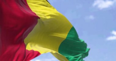 Açık bir günde rüzgarda dalgalanan Gine bayrağının ayrıntıları. Gine, Batı Afrika 'da bir kıyı ülkesidir. Seçici odaklanma. Yavaş çekimde kusursuz döngü