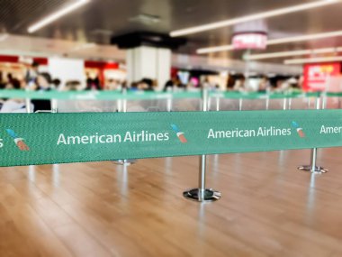 New York, ABD, Temmuz 2021: Beyaz Amerikan havayolları logolu yeşil kuşak bariyeri. American Airlines ABD merkezli büyük bir havayolu şirketidir. Seyahat ve havaalanı güvenliği